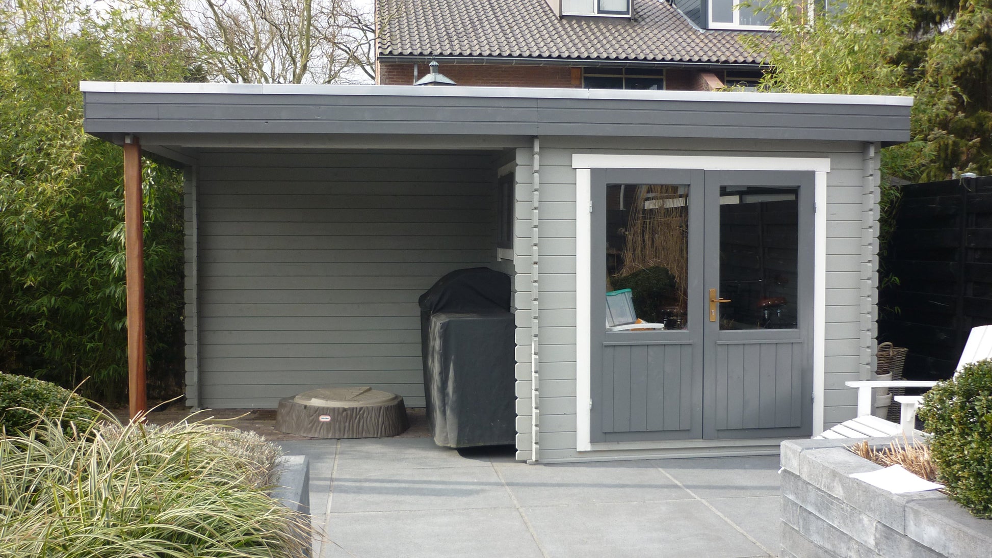 Luxe, duurzaam, modern, gecoat houten Interflex 2526Z tuinhuis met overkapping en berging geïnstalleerd in iemands tuin