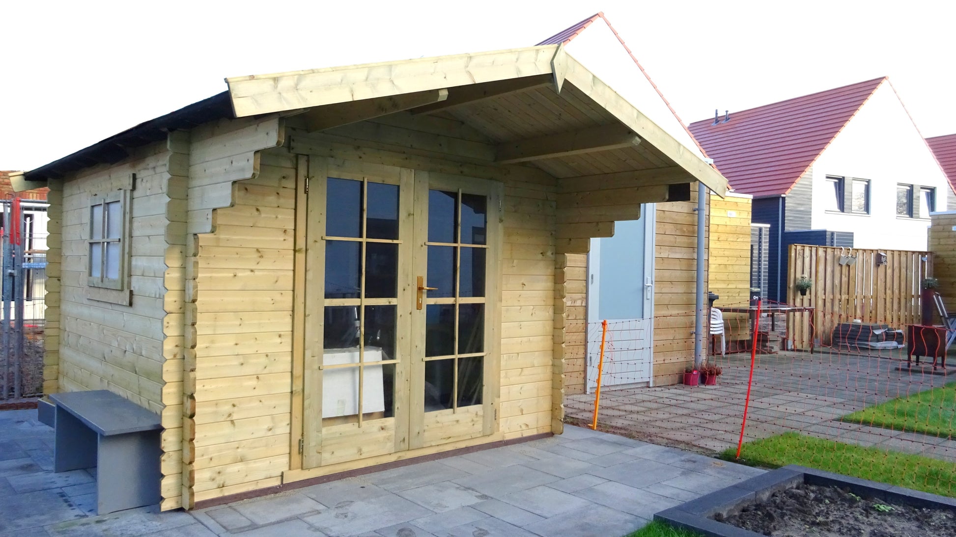 Licht houten tuinhuis Interflex 3032 met overkapping op terras in nieuwbouwwijk